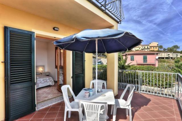 a table and chairs with an umbrella on a balcony at Casa Consuelo App. 1 (trilocale) in Capoliveri