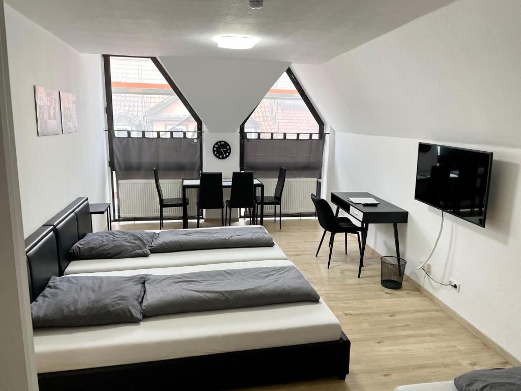 a bedroom with two beds and a table and chairs at Ferienwohnung Khorsandi Zwei in Coburg