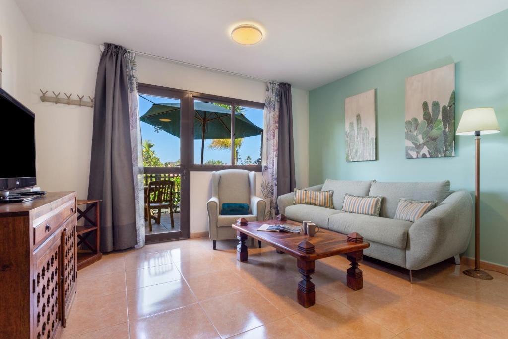 a living room with a couch and a table at Oasis Bahia Fronte Piscine in Corralejo