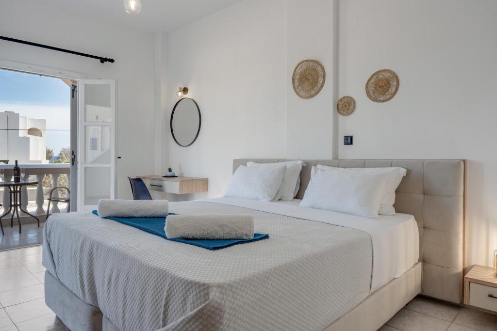 a white bed with two towels on top of it at 08 Double room Perivolos beach in Santorini