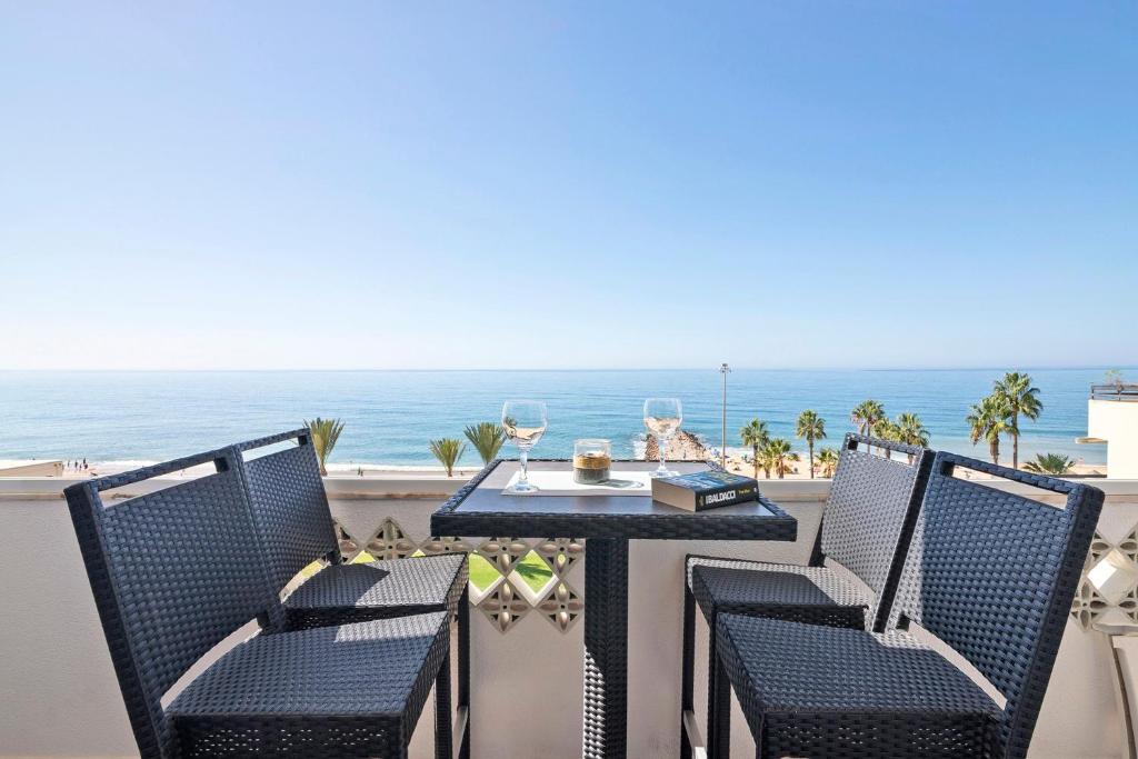 a table and chairs on a balcony with the ocean at Paraná in Quarteira