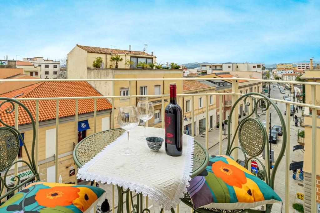 a bottle of wine sitting on a table on a balcony at Appartamento del corso in Olbia