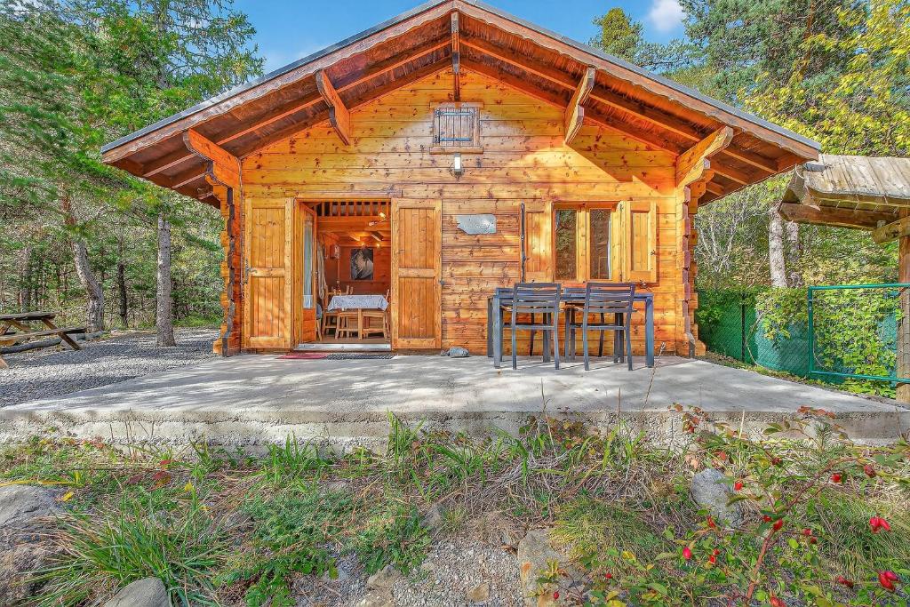 a cabin with a table and chairs in front of it at Chalet Le Mazet in Les Prats