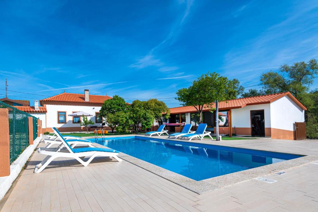 a villa with a swimming pool and two lounge chairs at Casa das Laranjas in Murtosa