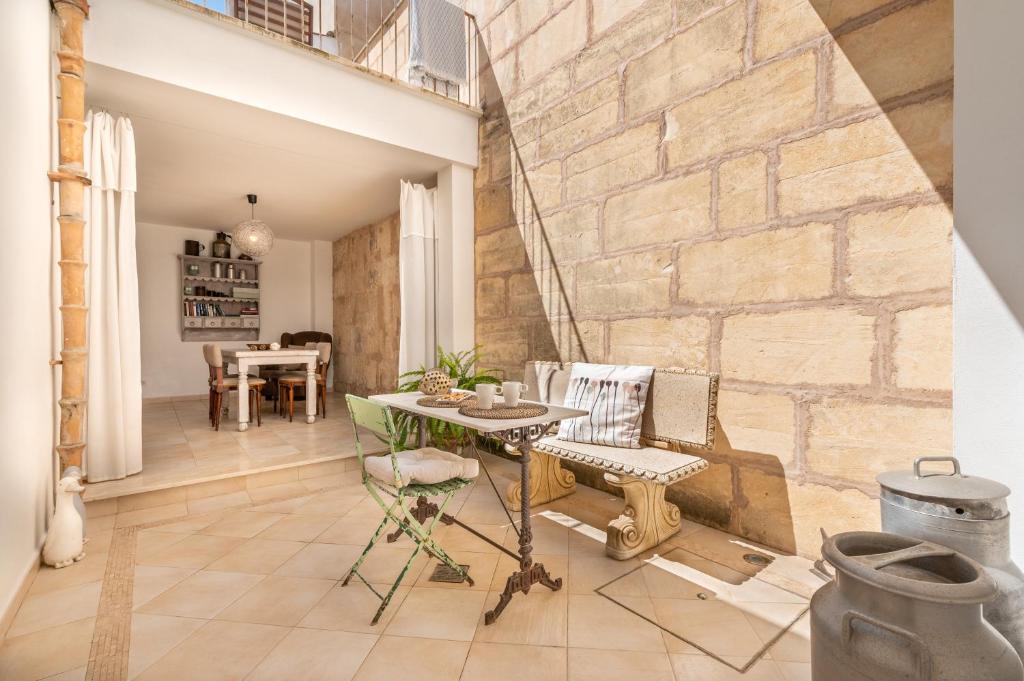 a living room with a stone wall and a table and chairs at Ca na Francesca in Pollença