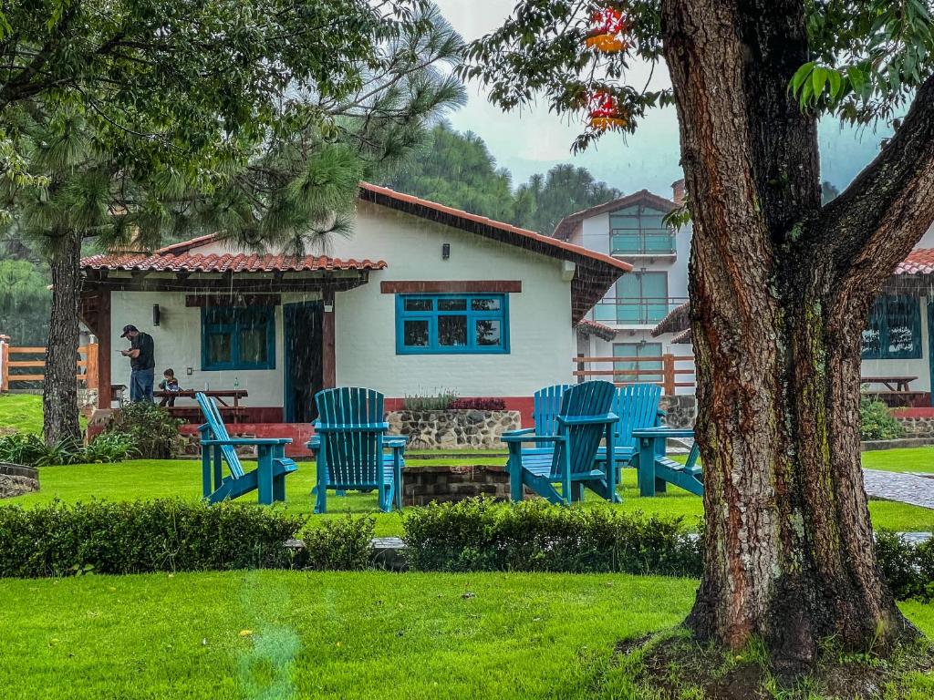 a group of blue chairs in front of a house at Cabañas Mazzatl 6 pax in Mazamitla