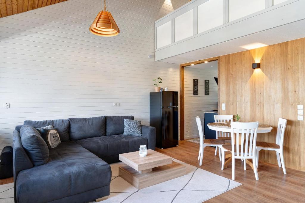 a living room with a blue couch and a table at Schwarzwaldtraum in Sasbachwalden