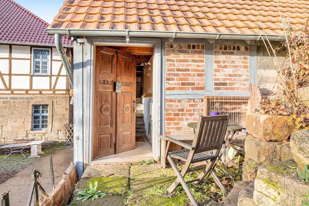 a wooden door to a brick house with a chair at Tiny House an der Werra in Bad Sooden-Allendorf