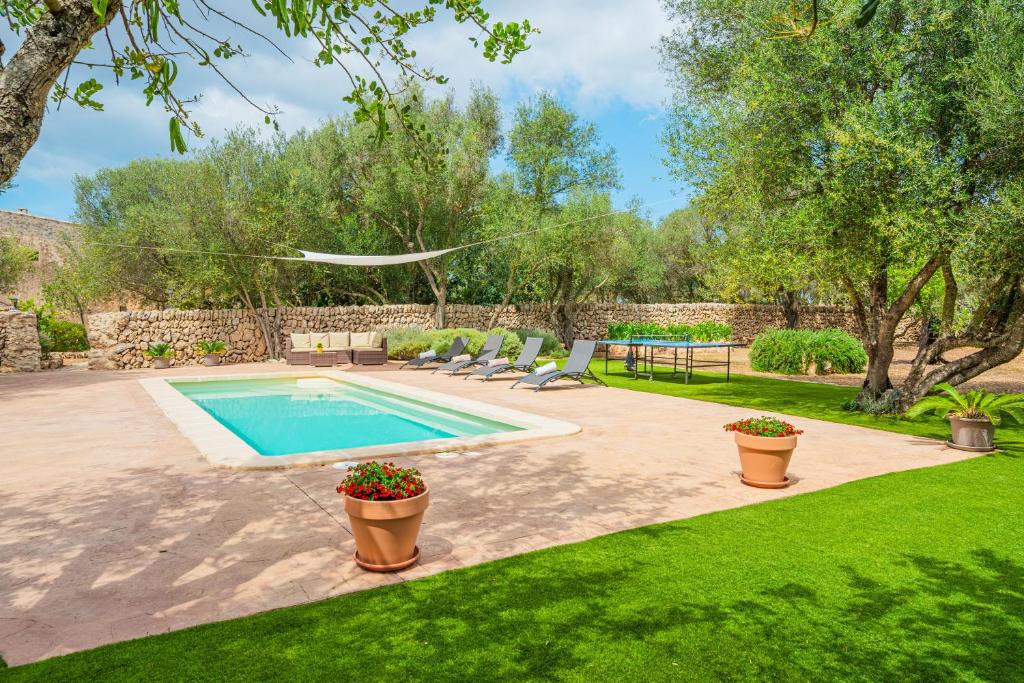 a swimming pool in a yard with chairs and a table at Can Garraseca in Llucmajor