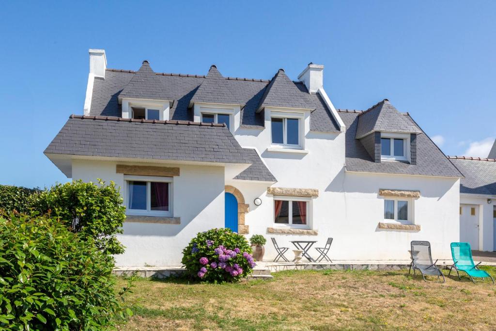 a large white house with a roof at Villa Nicole face mer in Trégunc