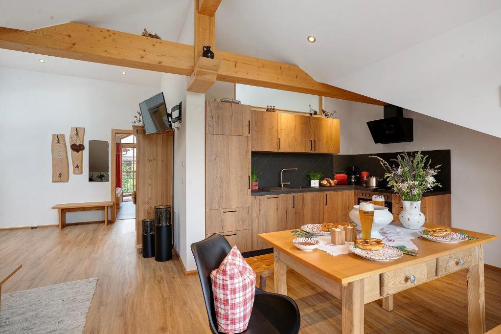 a kitchen and dining room with a wooden table at Neubau - Freundliche Fewo Bergblick in Höslwang