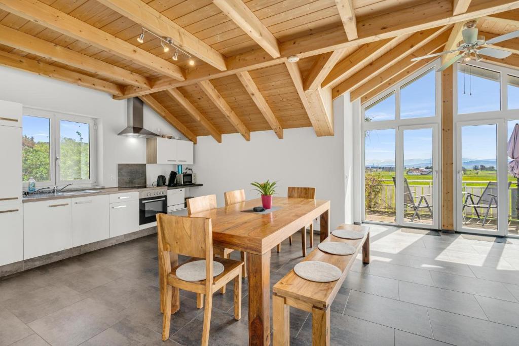 a kitchen and dining room with a wooden table and chairs at Cosy Home Allgäu in Haldenwang