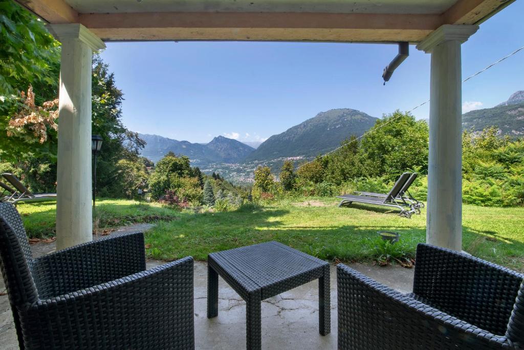 a table and chairs on a porch with a view at Casale La Selva Cottege piccolo in Piano Porlezza