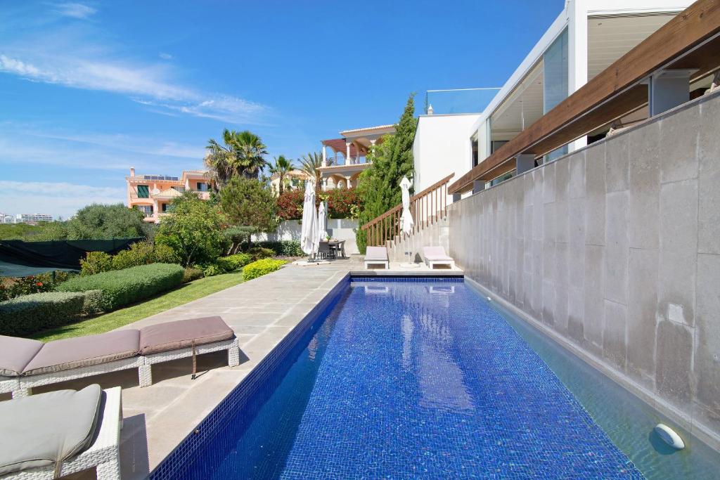 a swimming pool in the backyard of a house at Sweet Home Albufeira in Albufeira