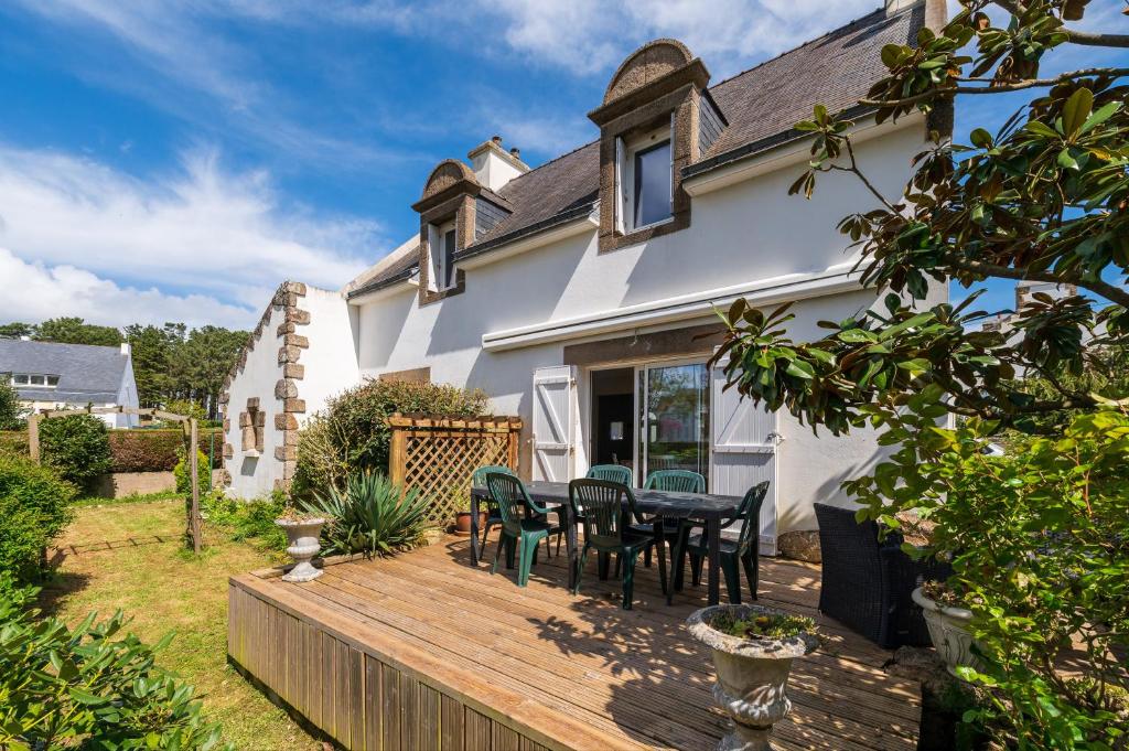 a wooden deck with chairs and a table in front of a house at Escapade Sérénité - Les Alignements in Carnac