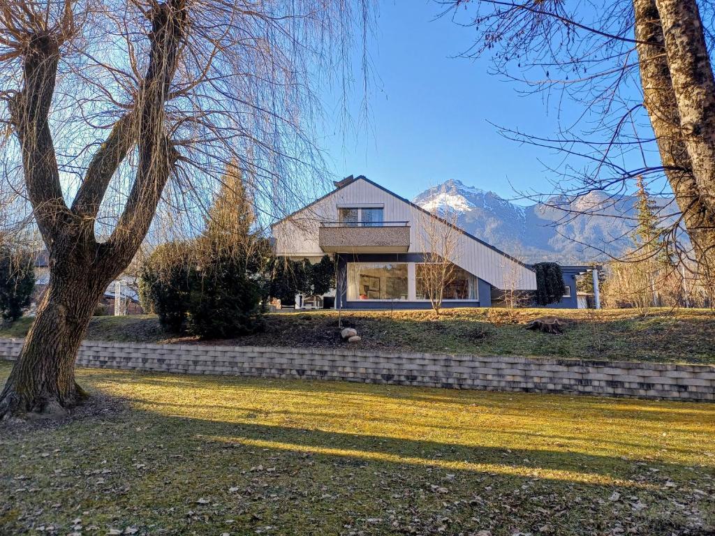 a house on a hill with mountains in the background at Haus Gutschi in Imst