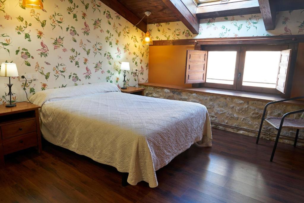 a bedroom with a large bed with flowers on the wall at La Platería I in Mambrilla de Castrejón