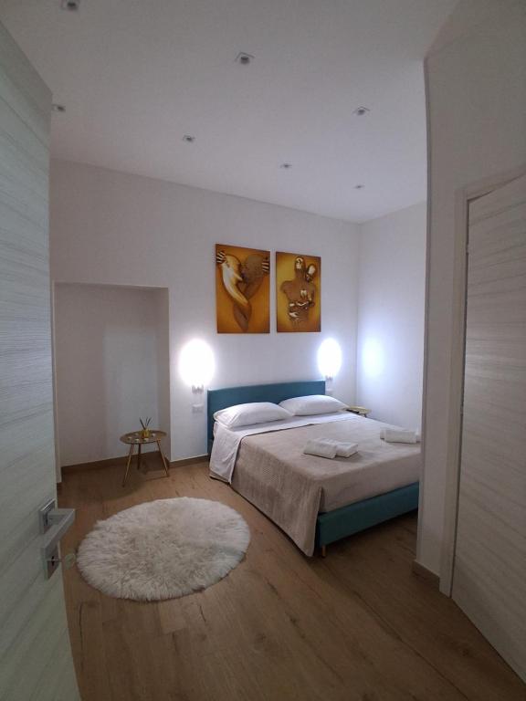 a bedroom with a bed and two paintings on the wall at Casa Arco Varano in Crotone