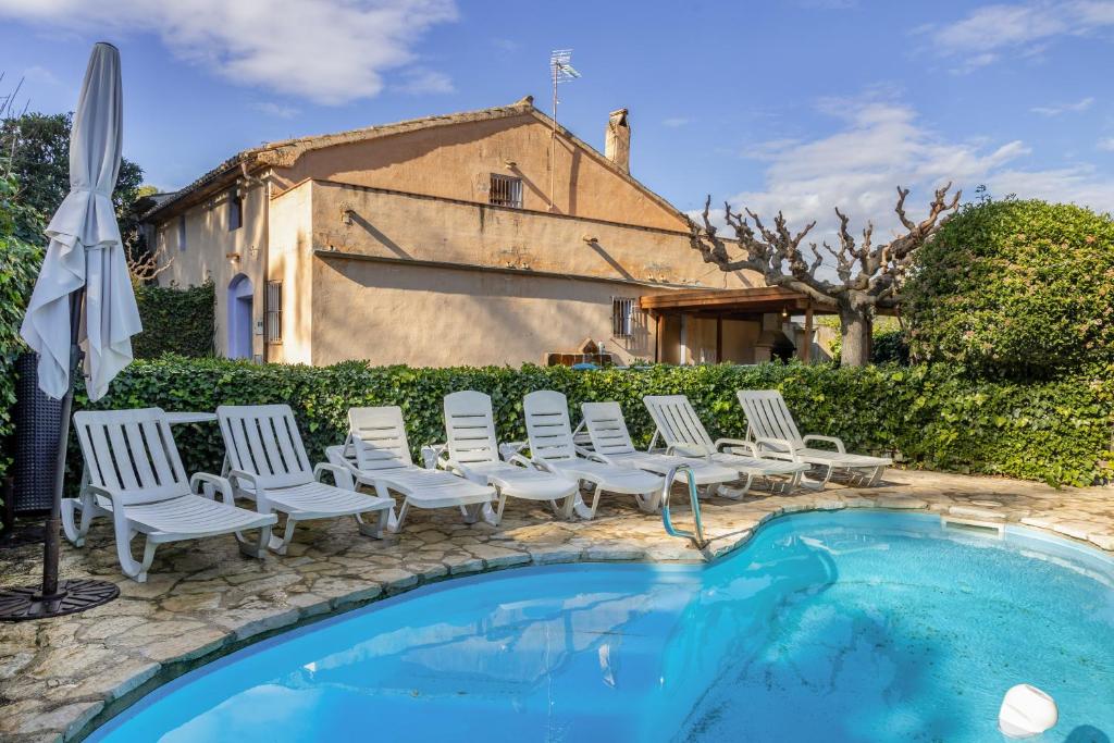 a group of chairs sitting next to a swimming pool at Cal Contra in Gélida