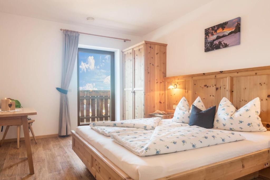 a bedroom with a large bed with a large window at Schildberghof Schlernblick in Kastelruth
