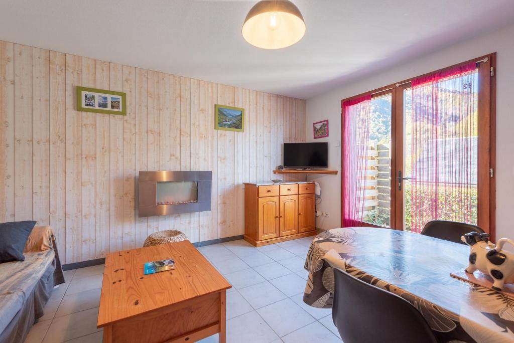 a living room with a table and a tv at Gite Clarabide in Loudenvielle