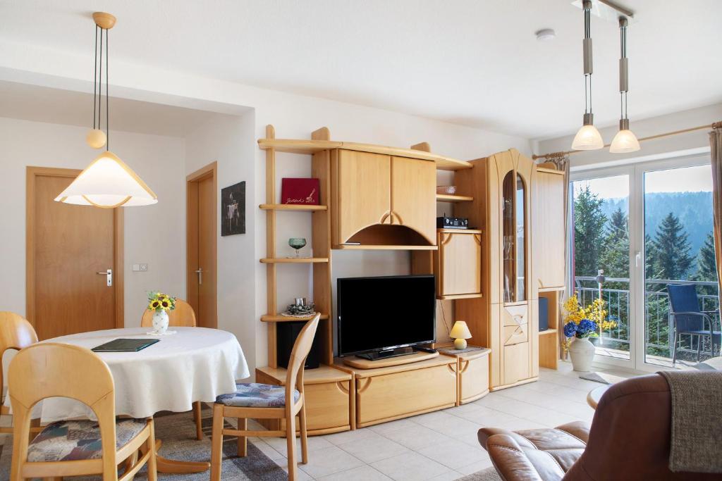 a living room with a table and a tv at Ferienwohnung Tannenblick 7-4 in Oberhof