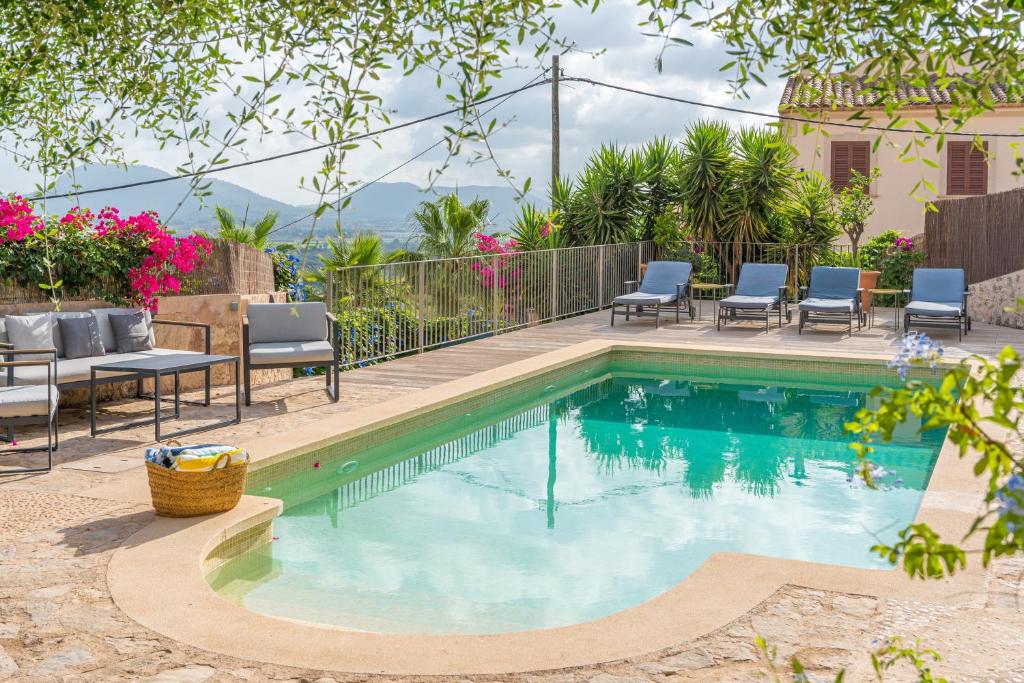 a swimming pool in a yard with chairs and a table at Numero Uno in Búger
