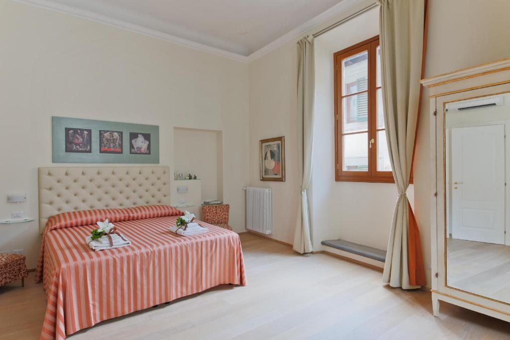 フィレンツェにあるProconsolo Superior Suiteのベッドルーム1室(ベッド1台、窓、鏡付)