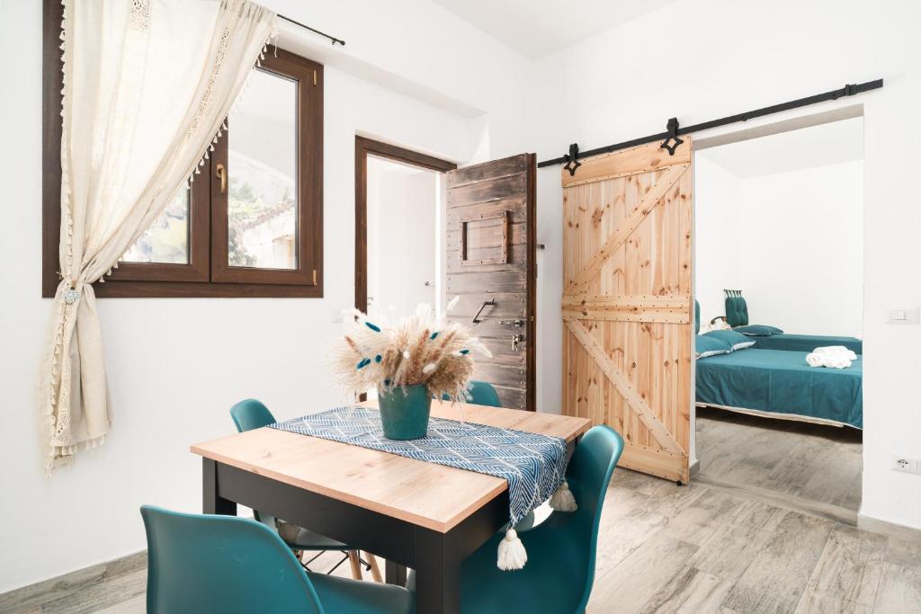 a dining room with a table and chairs and a bedroom at S' Istancu Vetzu in Irgoli