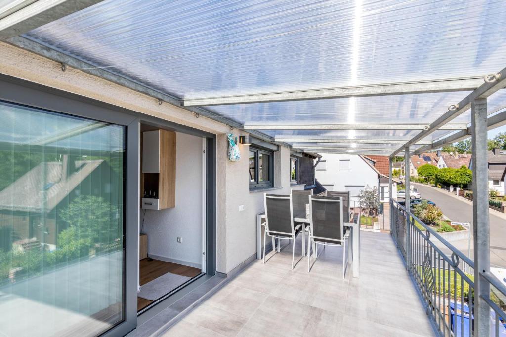 a conservatory with a table and chairs on a balcony at Ferienwohnug New Look in Geisenheim