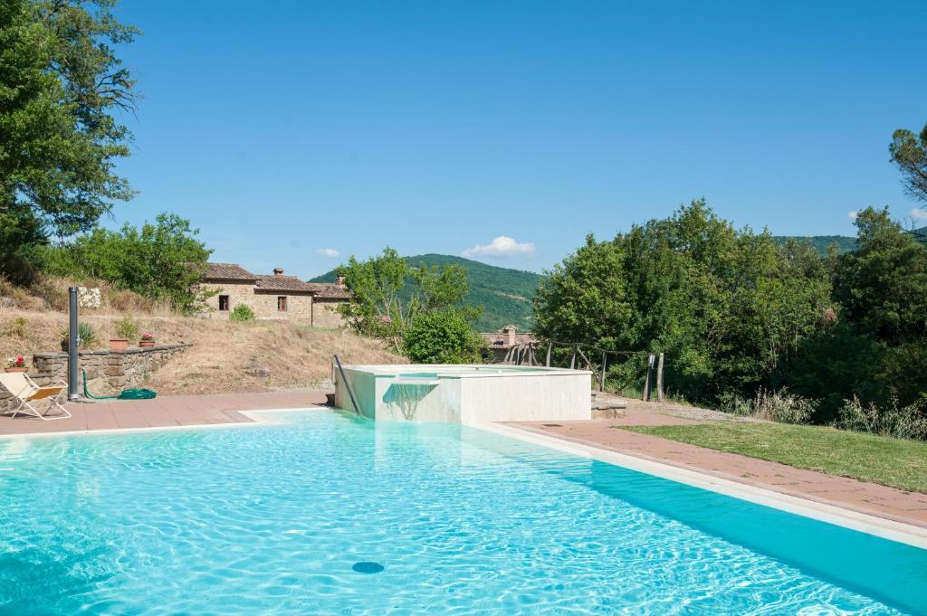 a swimming pool in front of a house at Appartamento Stalla - Cortona in Corgna