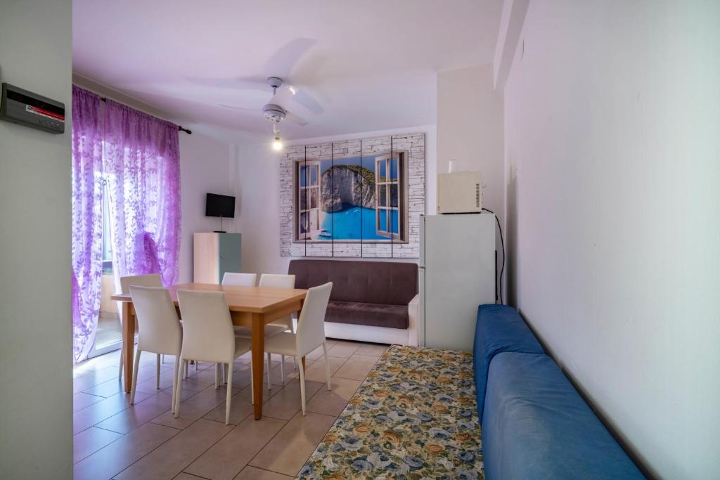 a kitchen and dining room with a table and a couch at Appartamento Andromeda B2 in Bibione
