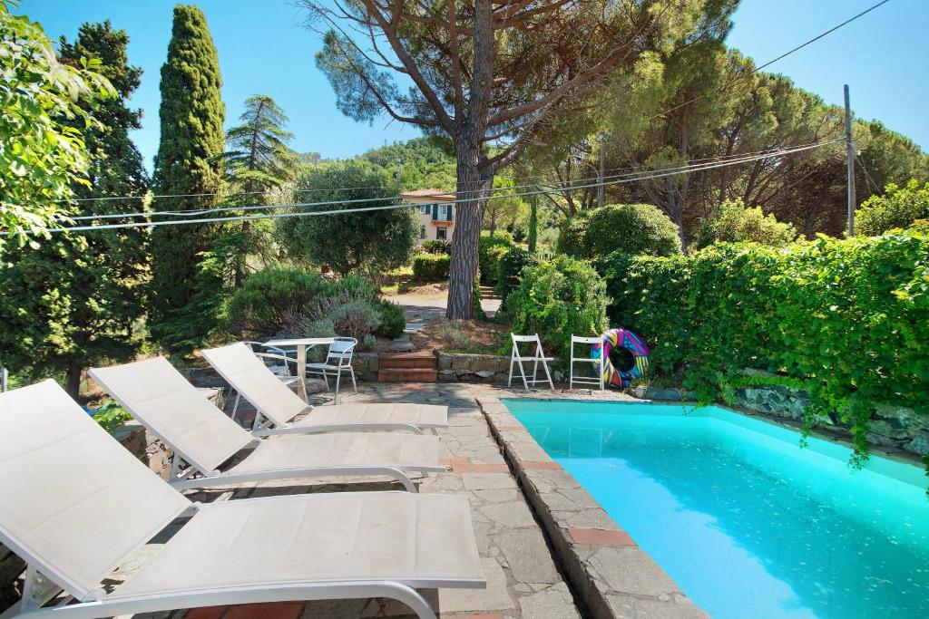 a pool with chaise lounge chairs and a swimming pool at Villa Mesco in Levanto