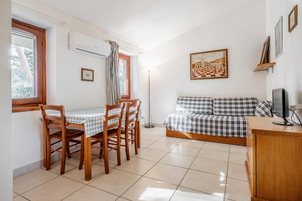 a room with a table and chairs and a bed at La Capannuccia A in Ansedónia