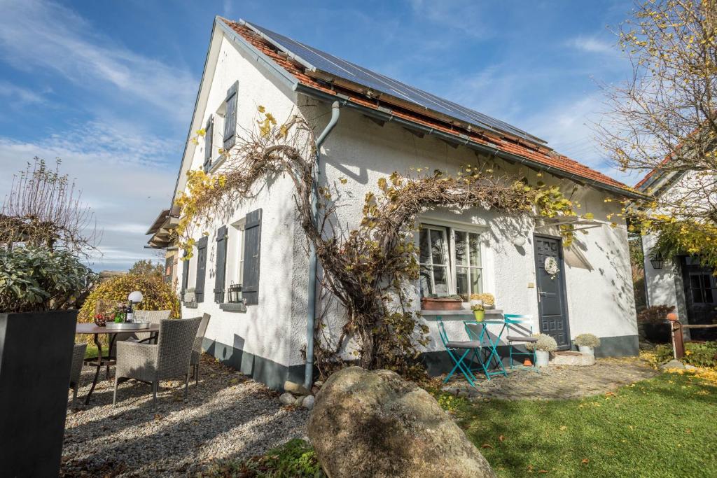 a white house with a table and chairs in front of it at Ferienhaus Landlust-Karsee in Wangen im Allgäu