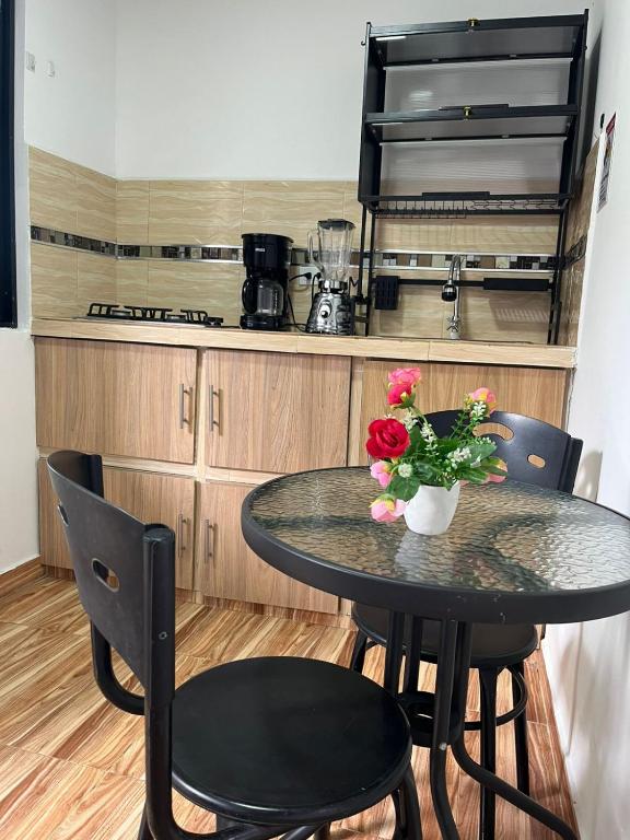 a table with a vase of flowers on it in a kitchen at 306ApartaesudioRomance in Arauca