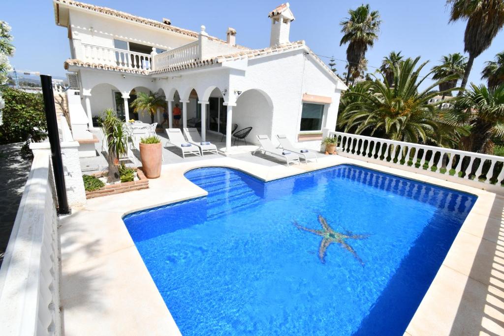 a villa with a swimming pool in front of a house at Villa with separate apartment in Mijas Costa