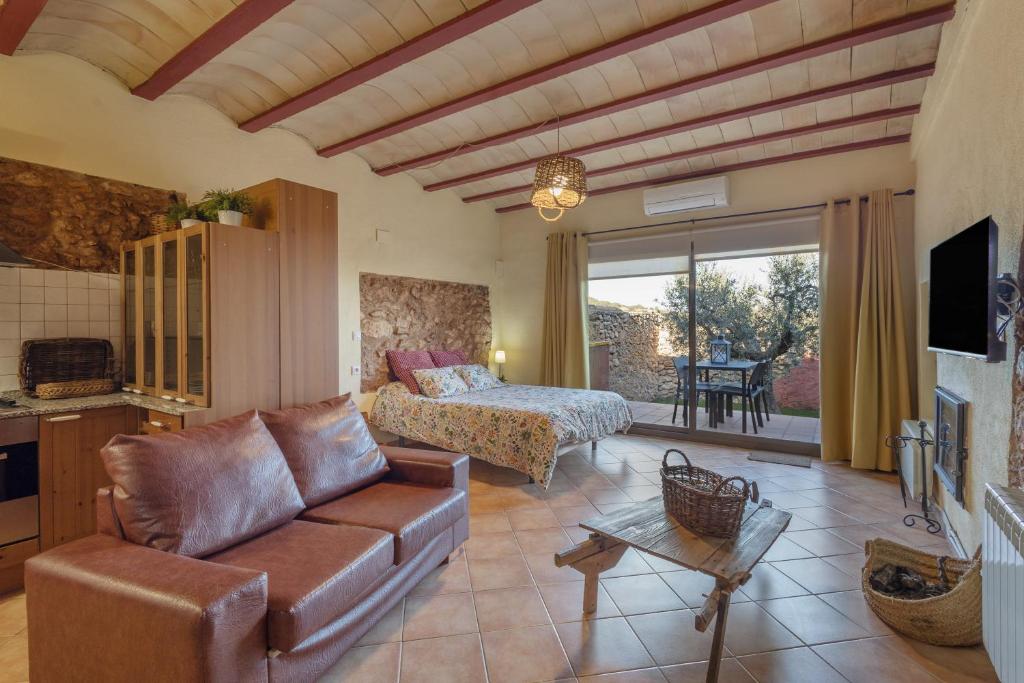 a living room with a couch and a bed at Loft Rural Orenetes ideal parejas in Sant Jaume dels Domenys