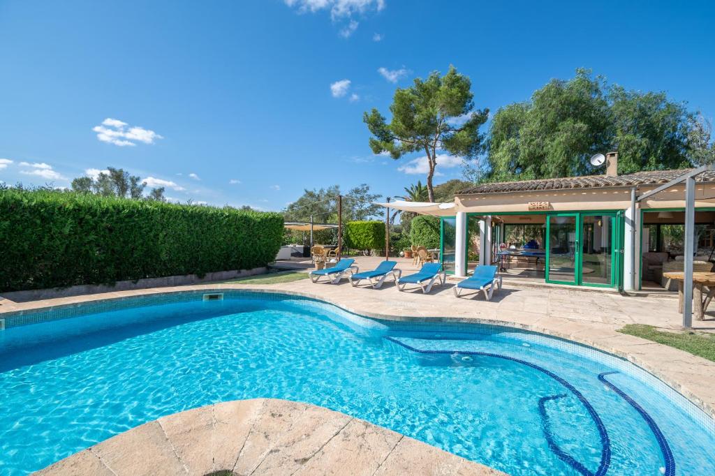 a swimming pool with chairs and a house at Can Rito in Islas Baleares