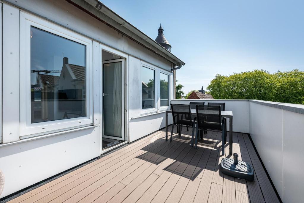a balcony with two chairs and a table on a house at Ferienwohnung mit Dachterrasse in Heide