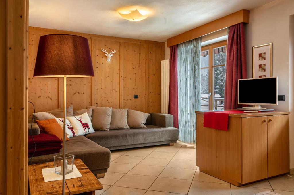 a living room with a couch and a television at Apartment Pordoi in Campitello di Fassa