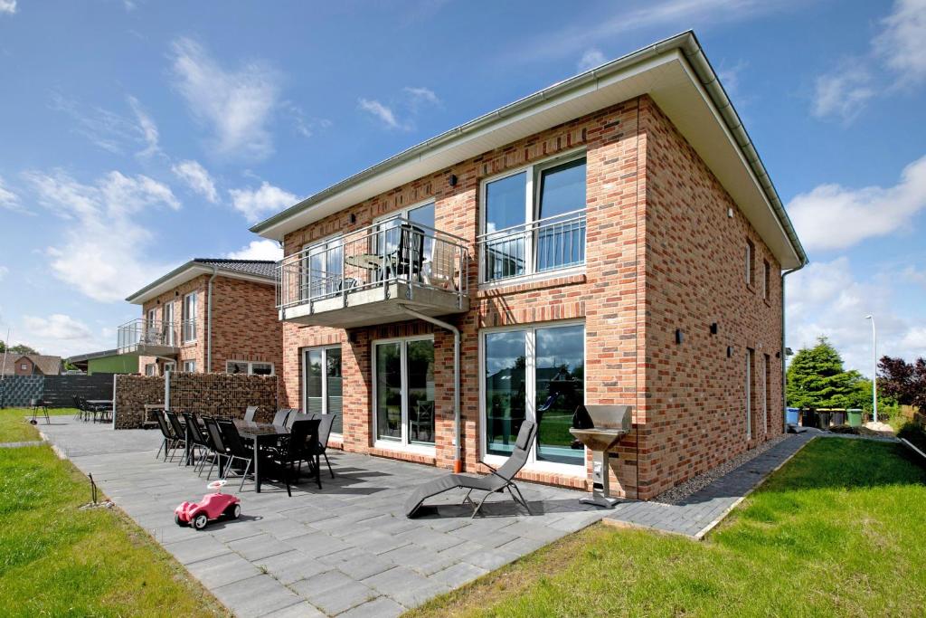 a brick house with a patio and a pink animal toy at Ferienhaus Ebbe in Schülp