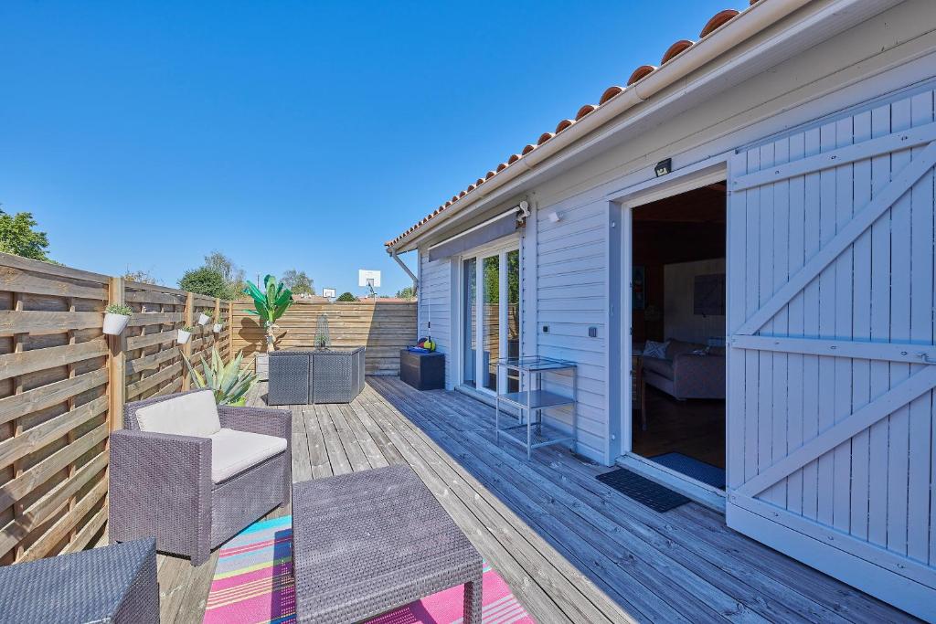 a wooden deck with a chair and a building at Gite Escale Bien Etre à Biscarrosse in Biscarrosse