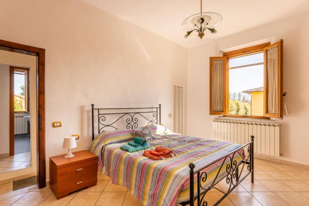 a bedroom with a bed and a window at Enza's Petite Maison in Santa Croce sullʼ Arno