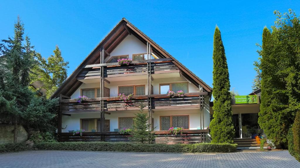 ein Haus mit Blumen auf den Balkonen und Bäumen in der Unterkunft Relax Apartments Tannenhof in Badenweiler