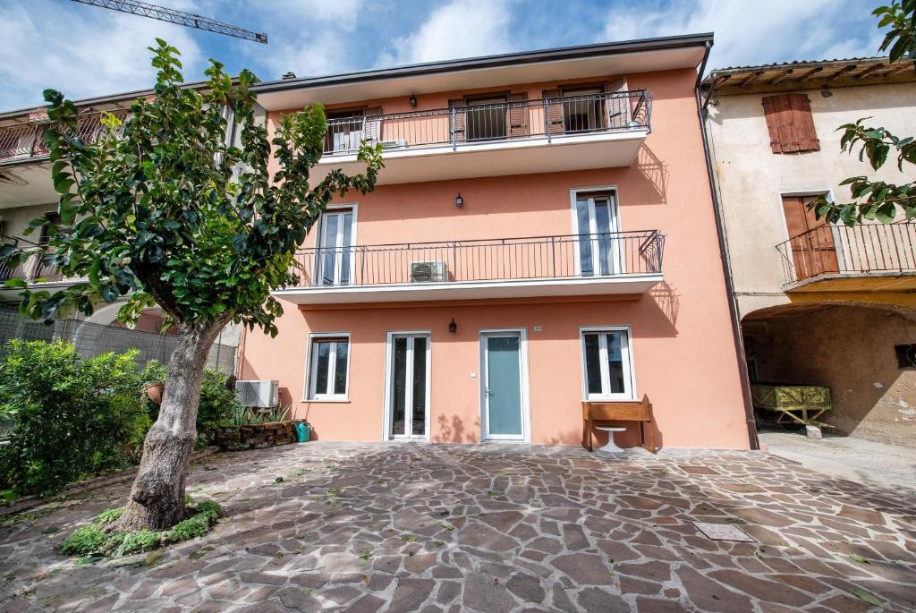 a pink building with a tree in front of it at Casa Solarolo in Montinelle