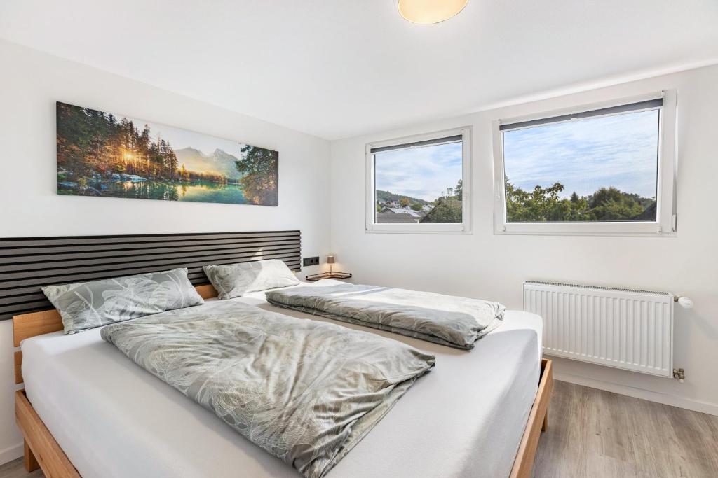 two beds in a bedroom with two windows at Auszeit Matzi in Öhningen