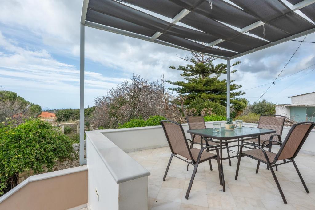 a patio with a table and chairs on a balcony at Palailimnos in Palaiólimnos