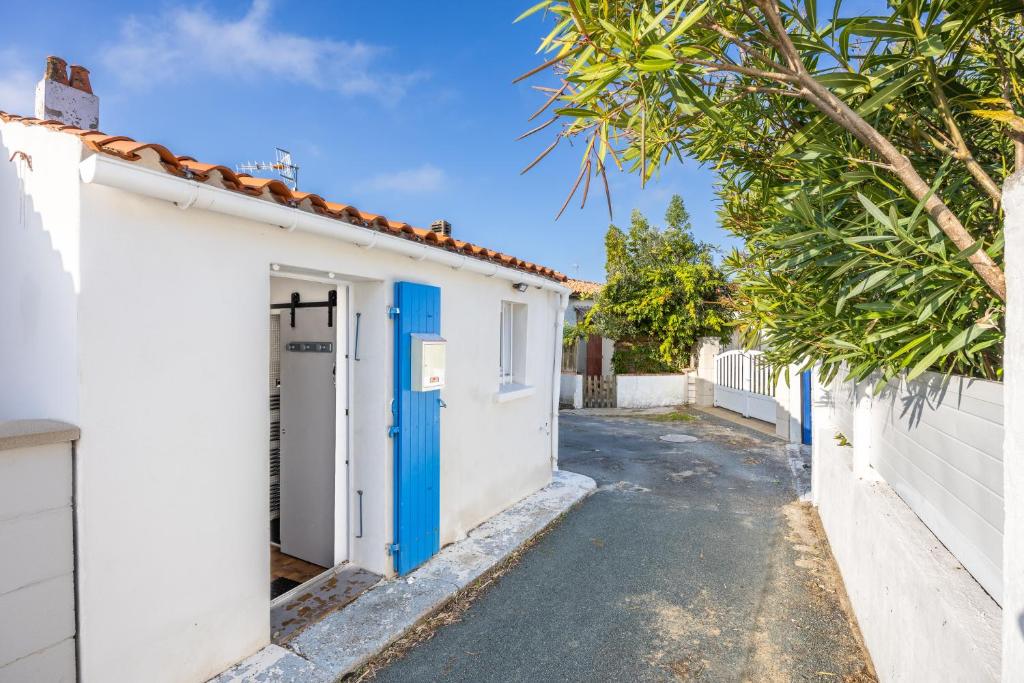 a house with a blue door on a street at Maison vacances La Terrière in La Tranche-sur-Mer