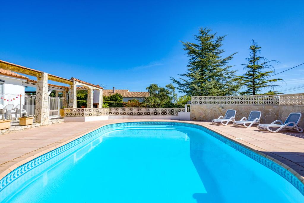 a swimming pool with two lounge chairs next to a house at Chez Gaston - Chambre in Saint-Drézéry